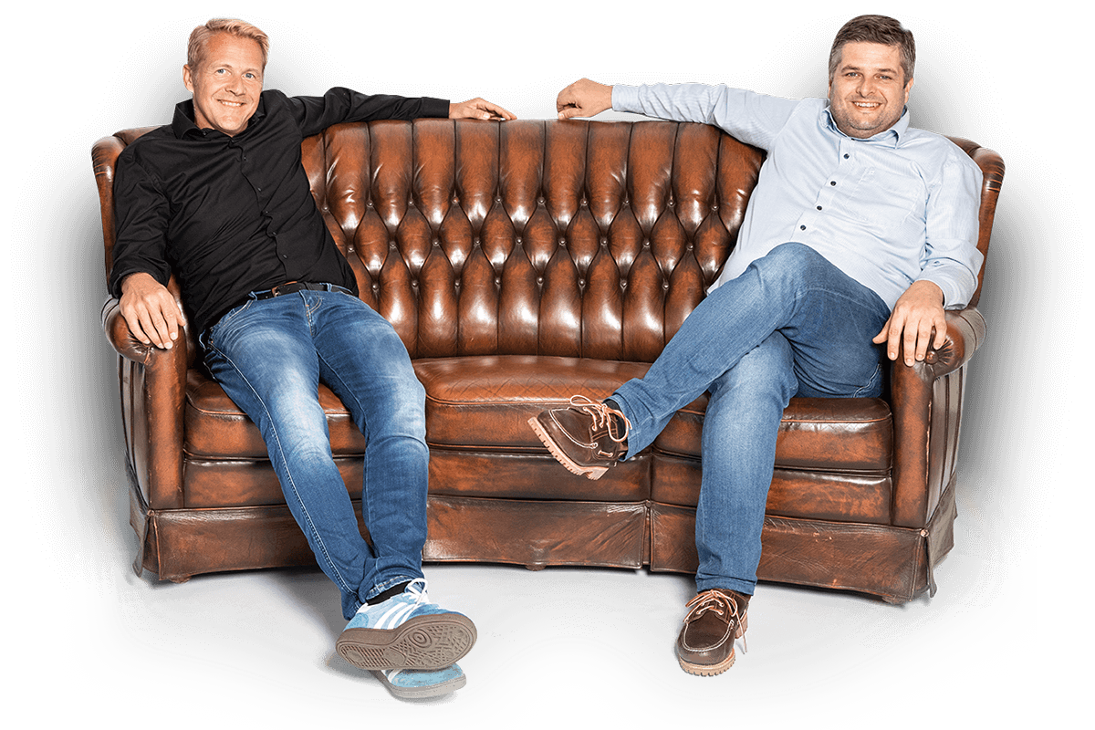 Frank Mühlenbeck und Philipp Pudelko sitzen auf einer Couch
